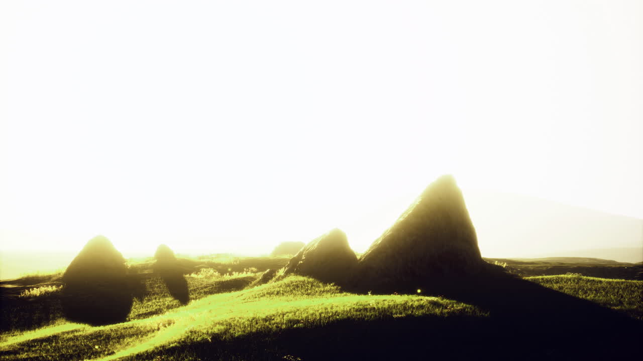 Serene landscape of rolling hills and rocky formations at sunset