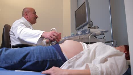 doctor performing ultrasound on a pregnant woman