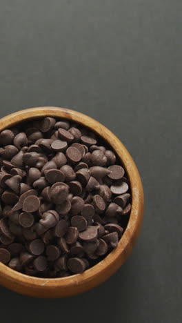 video de vista aérea de un cuenco de madera de chispas de chocolate sobre un fondo gris