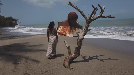 Ein-Schiffswrack-Im-Hintergrund-Und-Ein-Model-Im-Vordergrund,-Das-Die-Wellen-Am-Strand-Genießt