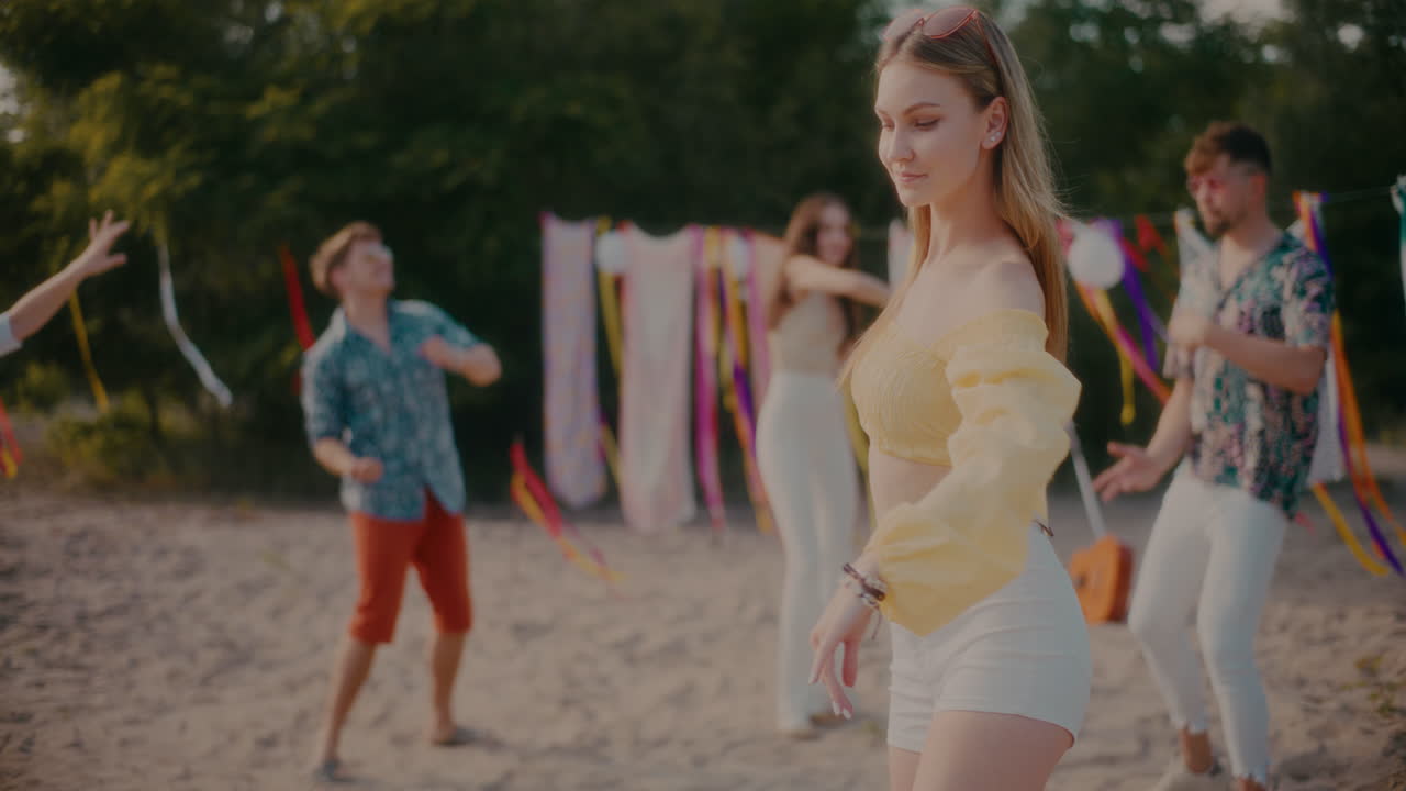 красивая женщина танцует на пляже против друзей.