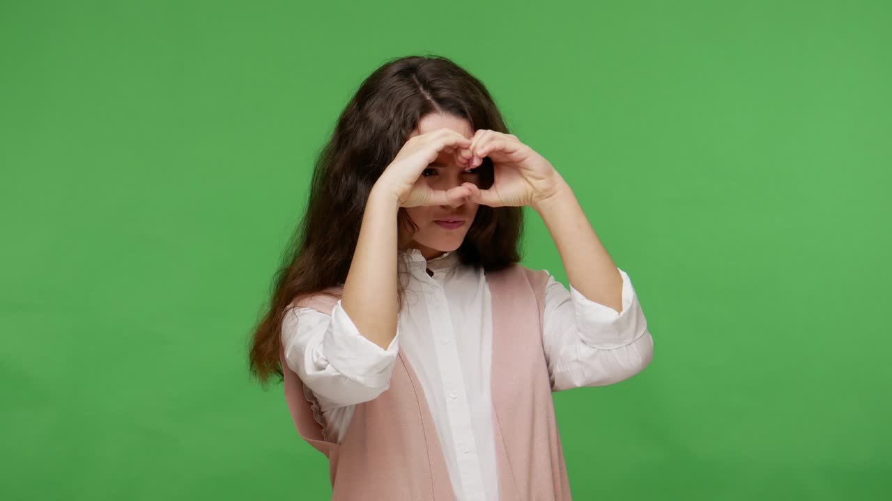 셔츠를 입은 호기심 많은 십대 갈색 소녀가 주의 깊고 호기심 넘치는 시선으로 주변을 둘러보고, 안경으로 세상을 관찰하고 있습니다.