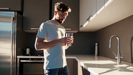 man drinking water in modern kitchen