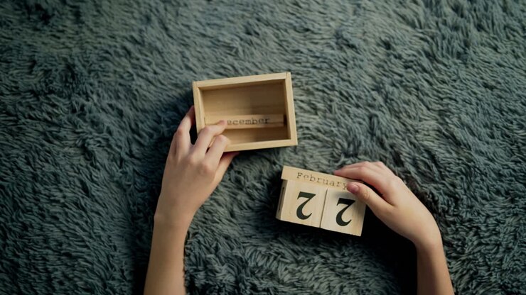 Hands of a boy flip over wood wooden cubes. Wooden cube calendar