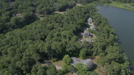 drone tracks right over beautiful landscape in cape cod with houses and a pond