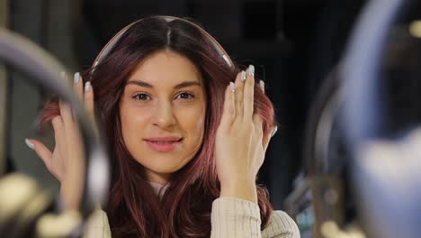 woman choosing headphones in speaker system store.