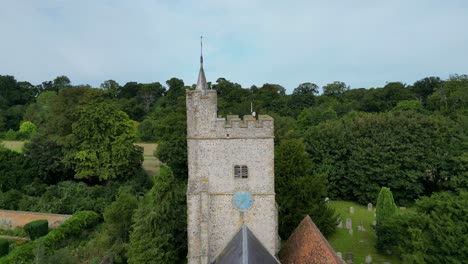 A-push-in-shot-over-the-roof-of-Holy-Cross-church-in-Goodnestone,-pushing-towards-the-church-tower