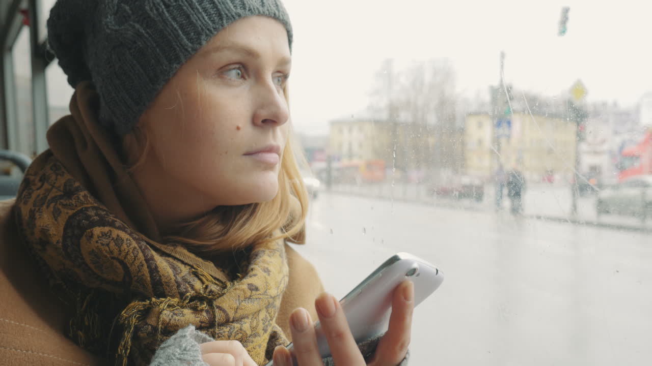 Vrouw sms't op mobiele telefoon tijdens busrit in de stad