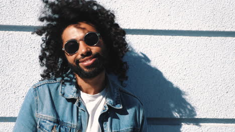 smiling man in denim jacket and sunglasses