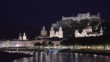 a wide-open view of fortress hohensalzburg, salzburg, austria at night when the artificial lighting is falling into the castle and its looks very beautiful