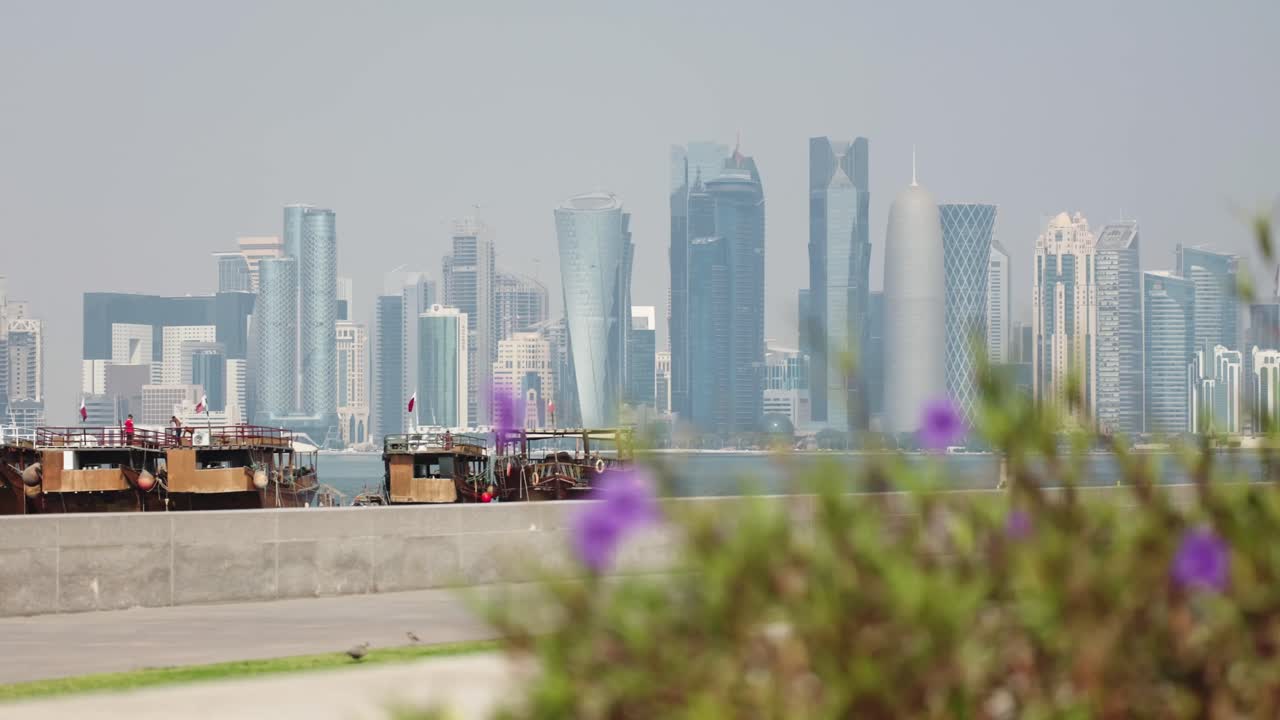 Sideskudd av Doha bysilhuett med skyskrapere og båter i marinaen