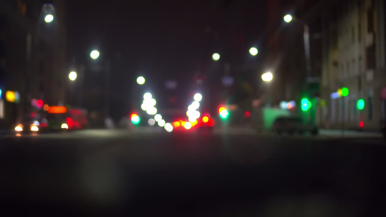 tráfico de automóviles en la ciudad nocturna, cámara dentro del automóvil. bokeh en fondo oscuro borroso
