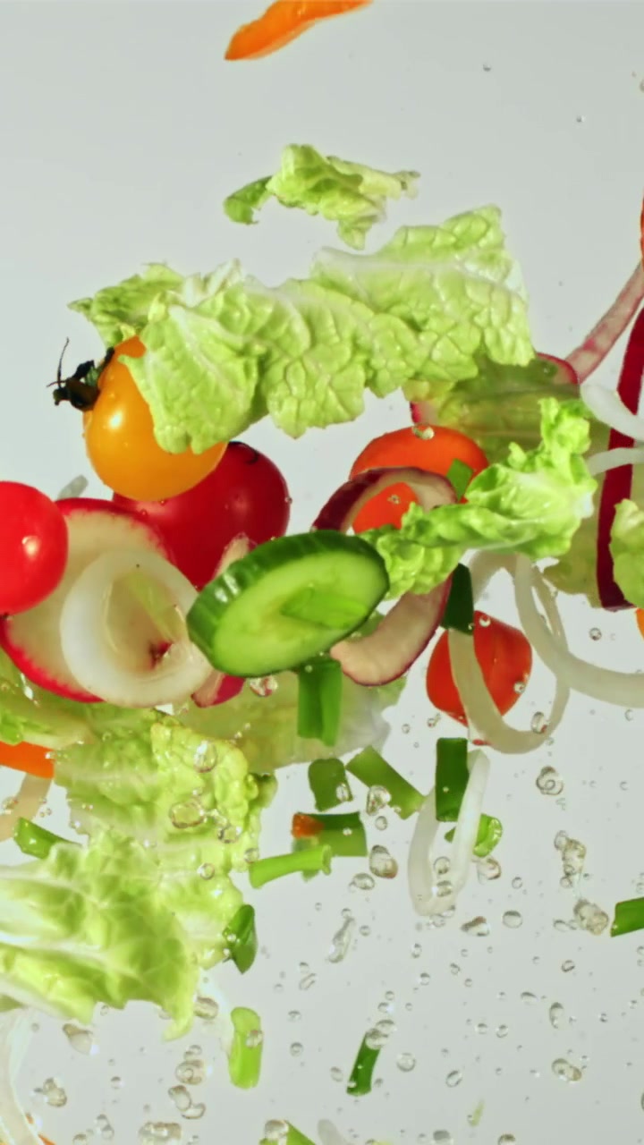 Verdure fresche colorate che cadono e schizzano nell'acqua