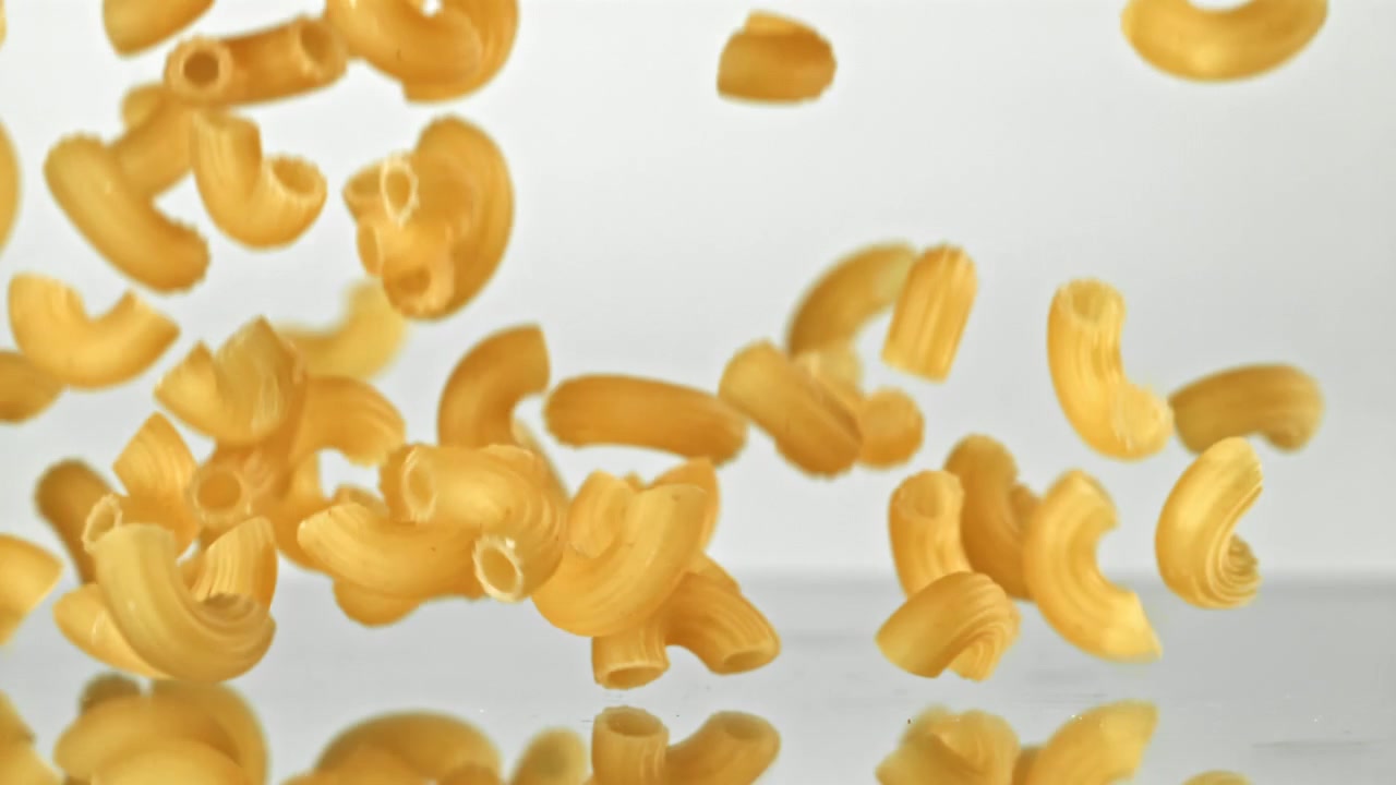 Pasta maccheroni a gomito cruda che cade al rallentatore