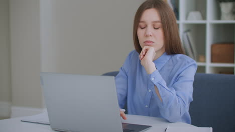 Una-Joven-Estudiante-Seria-Y-Reflexiva-Sentada-En-El-Escritorio-De-La-Oficina-En-Casa-Con-Una-Computadora-Portátil-Pensando-En-Ideas-De-Solución-De-Problemas-De-Búsqueda-De-Inspiración-Perdidas-En-El-Concepto-De-Pensamientos-Soñando-Mirando-Hacia-Otro-Lado