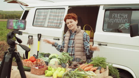 granjera filmando un anuncio del mercado de verduras con un teléfono inteligente