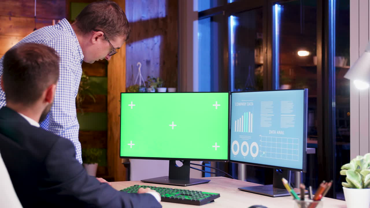 Businessmen analyzing data on computer screens with green screen