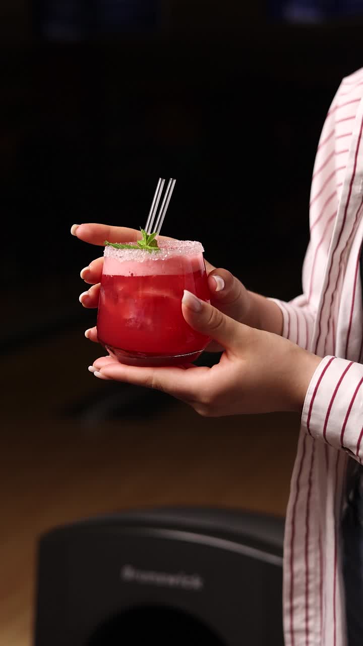 Woman holding a refreshing red cocktail