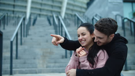 Laughing-couple-looking-to-side-in-slow-motion.-Sporty-man-pointing-finger.