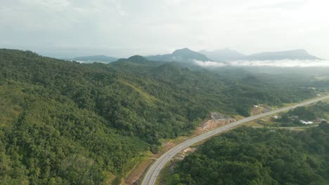 beautiful drone view of bau to lundu pan borneo highway during morning sunset with mountain and valley, green forest,sarawak, borneo.