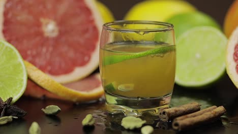 lime slice falls into a glass cup with an alcoholic cocktail