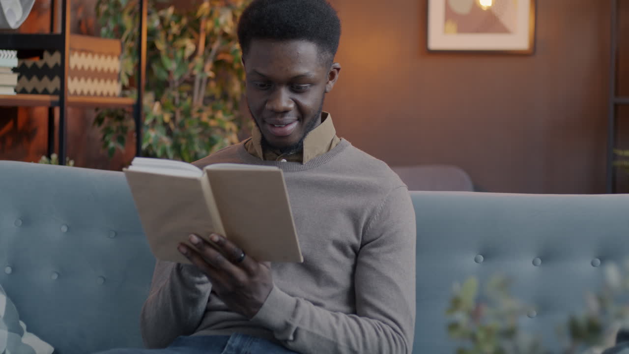 Ein Mann liest ein Buch auf einer Couch