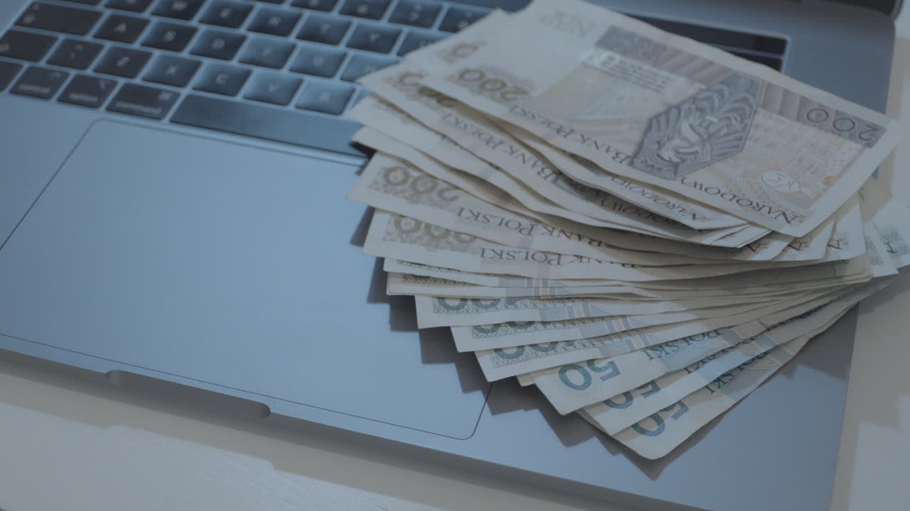 мужчина полирует банкноты на клавиатуре ноутбука