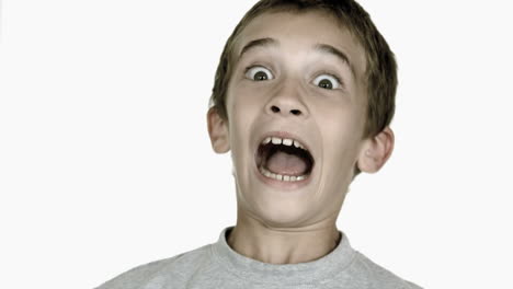 Boy-grimacing-against-white-background