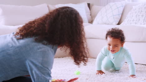 Black-toddler-boy-crawling-around-his-kneeling-young-mother