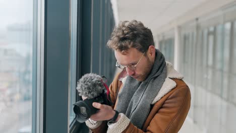 young guy blogger takes video on camera with his hands