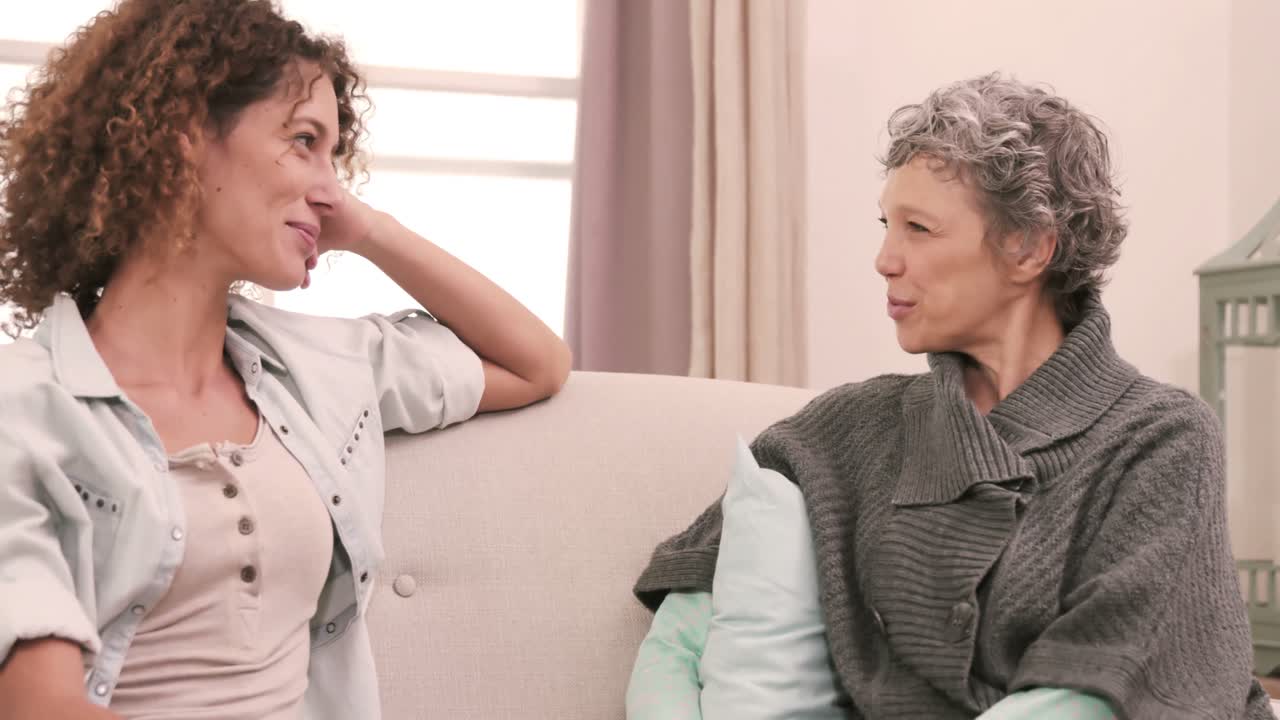 소파 에 앉아 이야기 하는 미소 짓는 여자 들