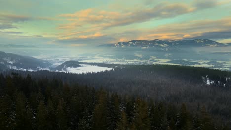 drone pullback shot over the bc forests close to enderby , british columbia during sunset in winter