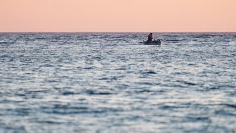 pescador local en un pequeño barco de pesca frente a la costa croata al atardecer