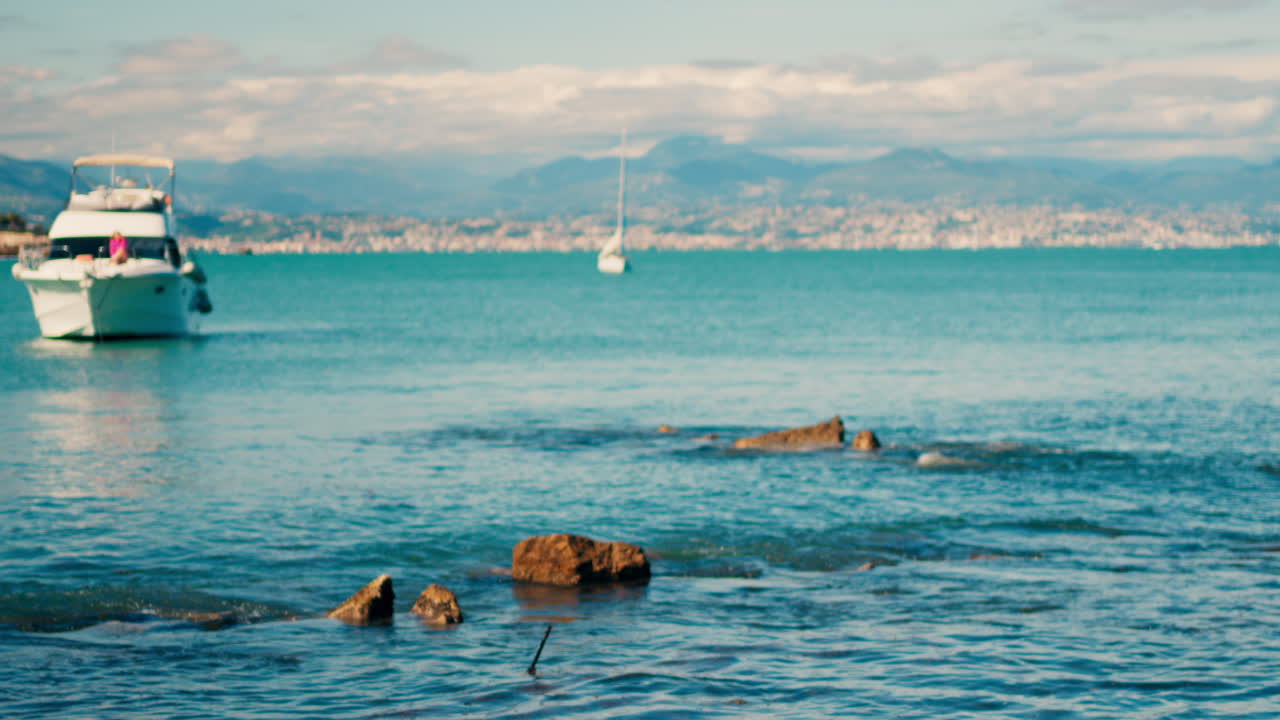 Boat floating on the sea with the town of Bandol, France on the background