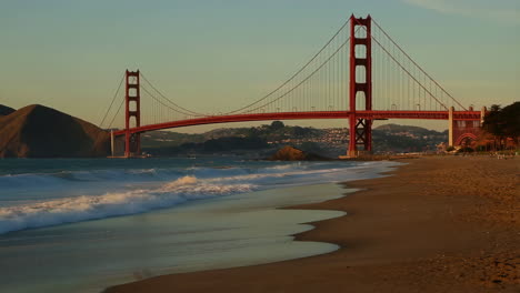 golden gate bridge from a beach at sunset