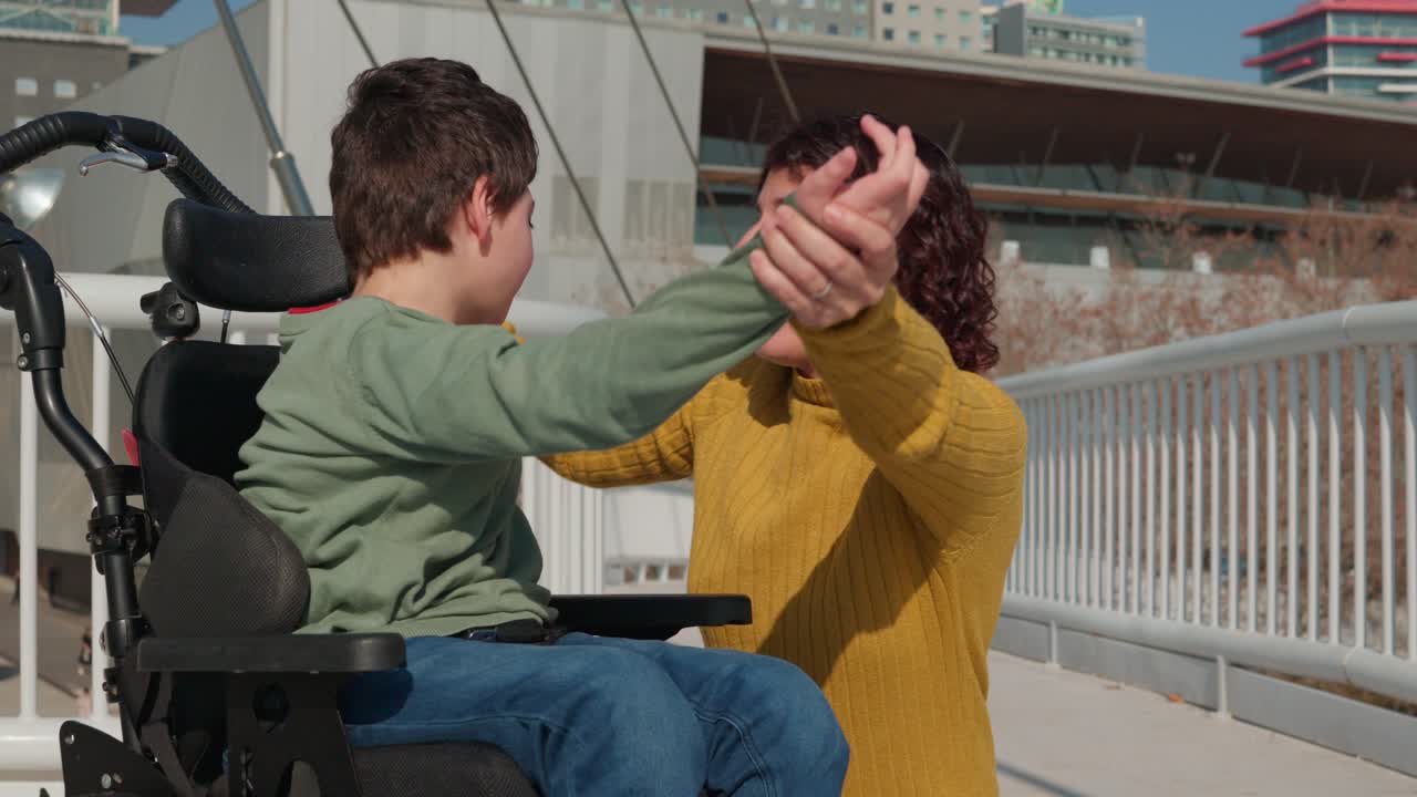 Mother and son in wheelchair on a bridge