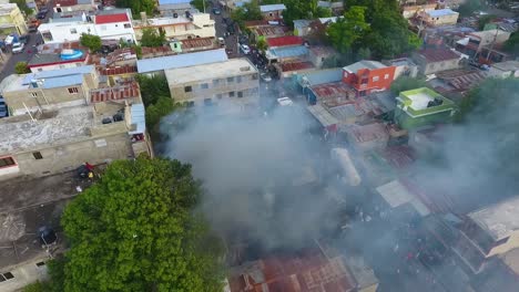 vista aérea alrededor de un edificio humeante, ardiendo en una calle concurrida de la ciudad - dando vueltas, disparo de drones