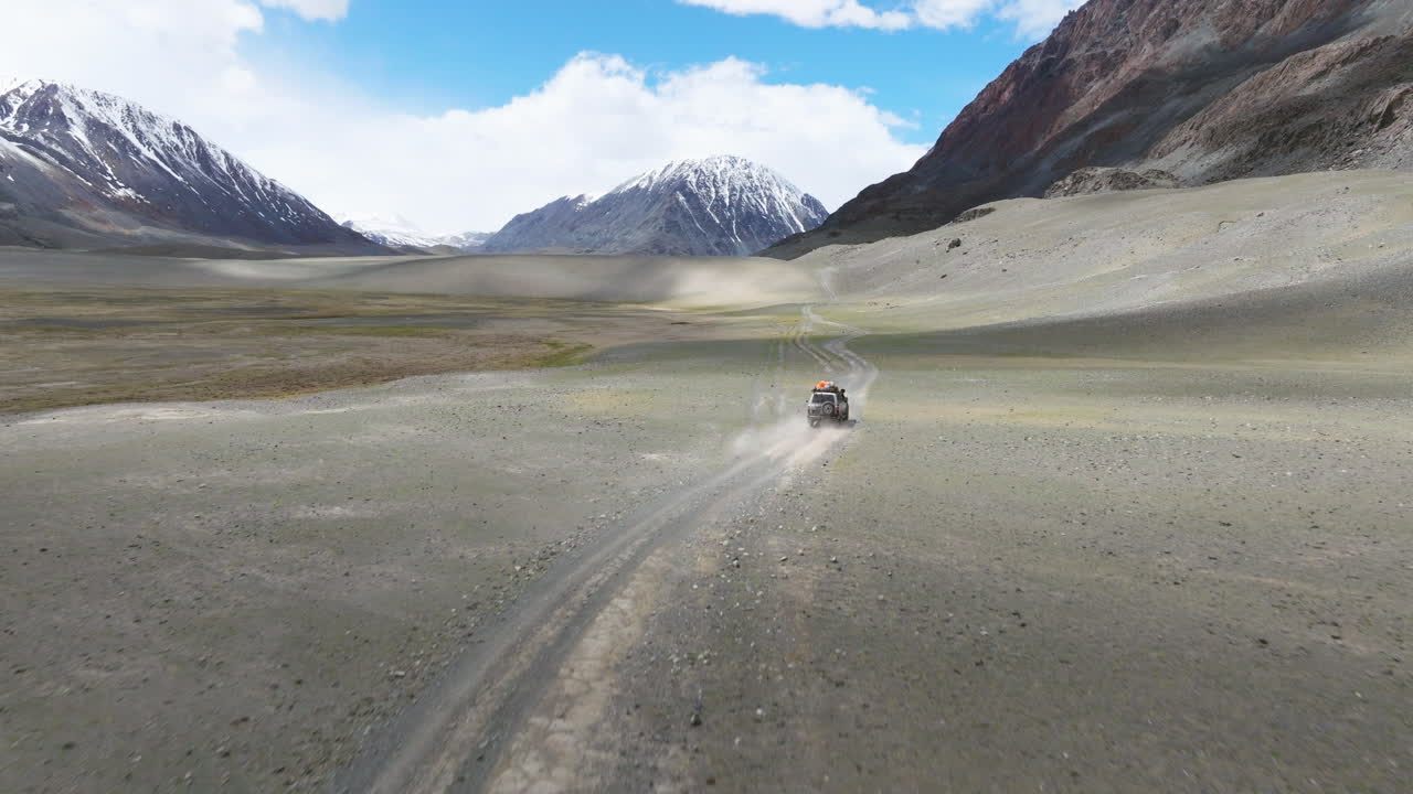 Veduta aerea di un veicolo che guida in fuoristrada attraverso la Valle di Tsagaan Gol nelle Montagne Altai della Mongolia.