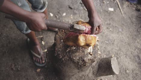 African-man-cutting-meat-with-axe