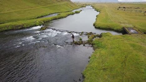 aerial video of man fishing for salmon in fossalar river in iceland