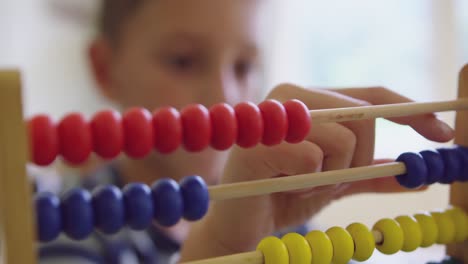 Boy-learning-mathematics-with-abacus-in-a-comfortable-home-4k