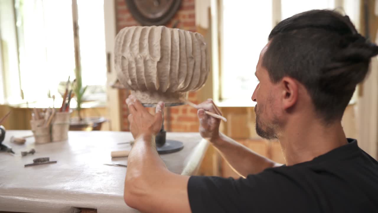 toma de rotación de un alfarero profesional dando forma a una olla de cerámica única. artista trabajando en el taller. creando una obra maestra. toque final