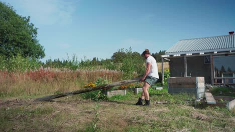 a man is carrying a concrete beam for the construction of a greenhouse in indre fosen, norway - static shot