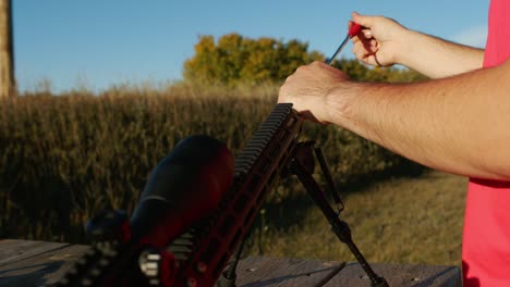 limpieza del cañón del arma en el campo de tiro soleado, rifle táctico, alcance de francotirador de largo alcance en servicio