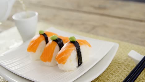 sushi in tray with tea in cup