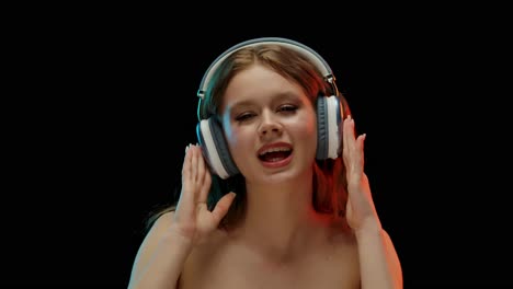 young woman expressing emotions while listening to music with headphones