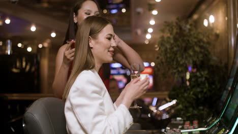 women playing slot machine.