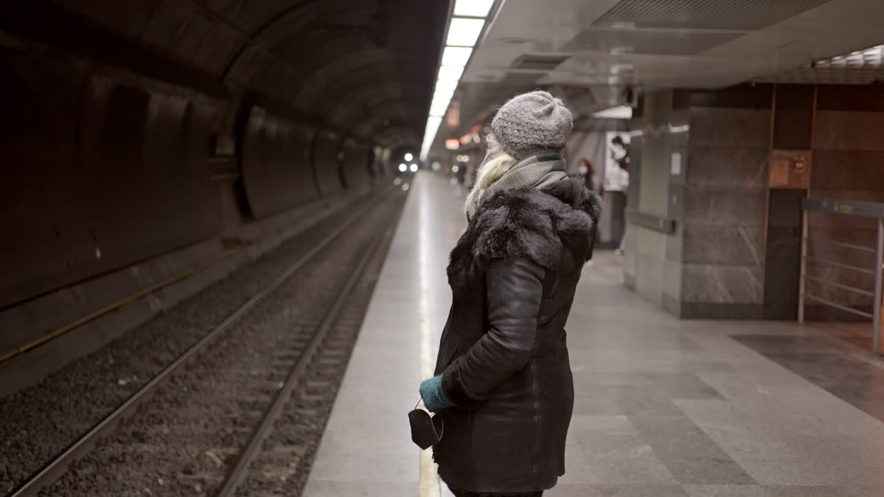 Woman Waiting for a Train on a Subway Platform