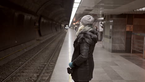 woman waiting for a train on a subway platform