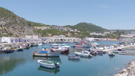 a panning shot of a harbour full of fishing boats in a sleepy portuguese town sesimbra